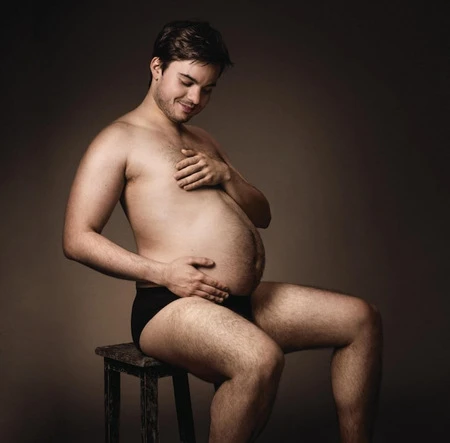 Мужчина сидит на стуле на темном фоне